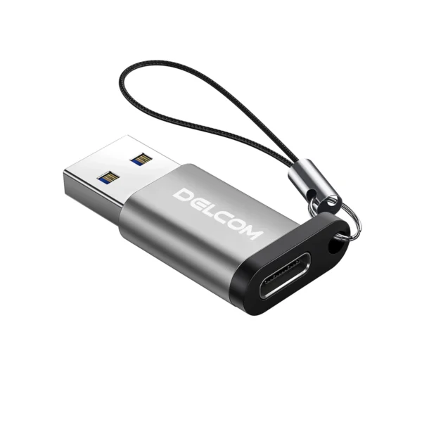 Adaptador USB-C Hembra a USB-A 3.0 Macho Delcom: ¡Conecta tus Cables USB-C en Cualquier Puerto USB!, Pequeño adaptador Delcom DOTG-USB3.0 de color plateado, mostrando el conector USB-A macho y el puerto USB-C hembra, con su cordón de seguridad de nylon, producto de HD Multimedia.