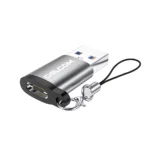 Adaptador USB-C Hembra a USB-A 3.0 Macho Delcom: ¡Conecta tus Cables USB-C en Cualquier Puerto USB!, Pequeño adaptador Delcom DOTG-USB3.0 de color plateado, mostrando el conector USB-A macho y el puerto USB-C hembra, con su cordón de seguridad de nylon, producto de HD Multimedia.